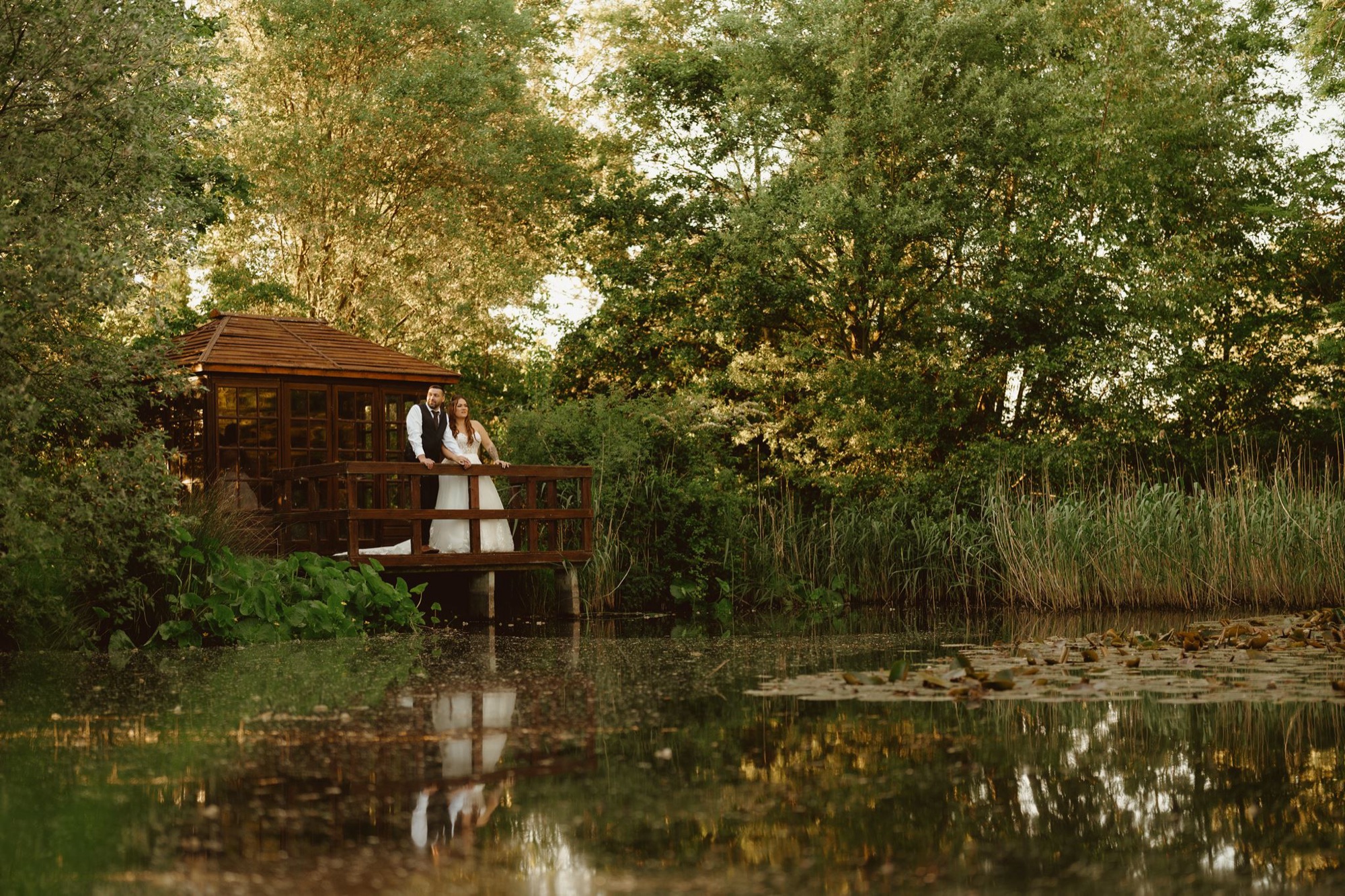A couple embrace beside the water