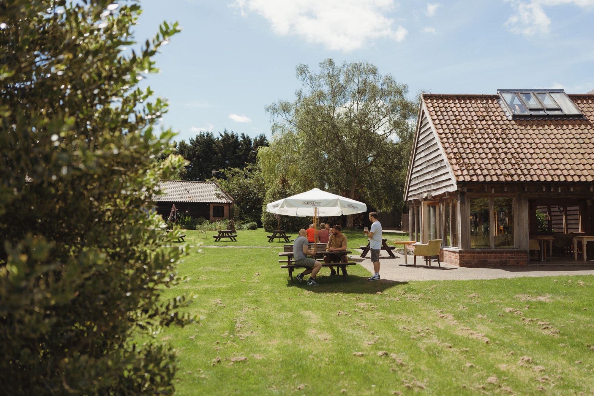 The thatched exterior of the Crooked Barn with wildflowers