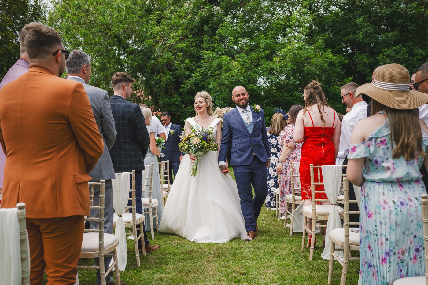 A couple walking back down the outdoor aisle