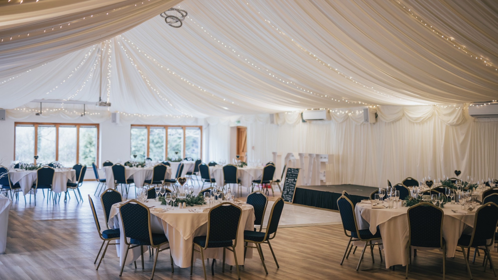 Ivy Hall dressed for a wedding reception beneath a draped canopy of fairy lights