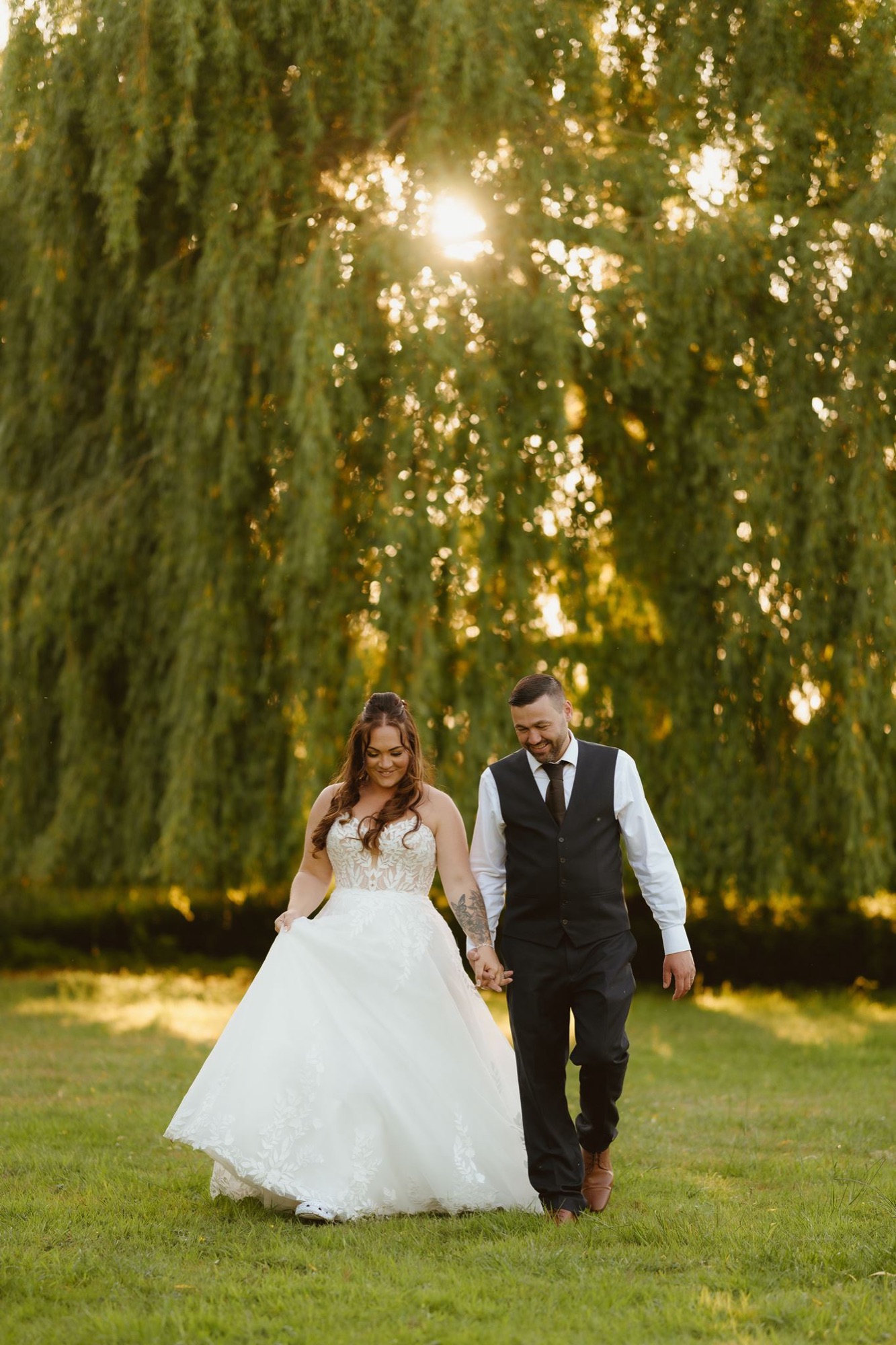 Newlyweds beneath a grand tree in the gardens at Ivy House
